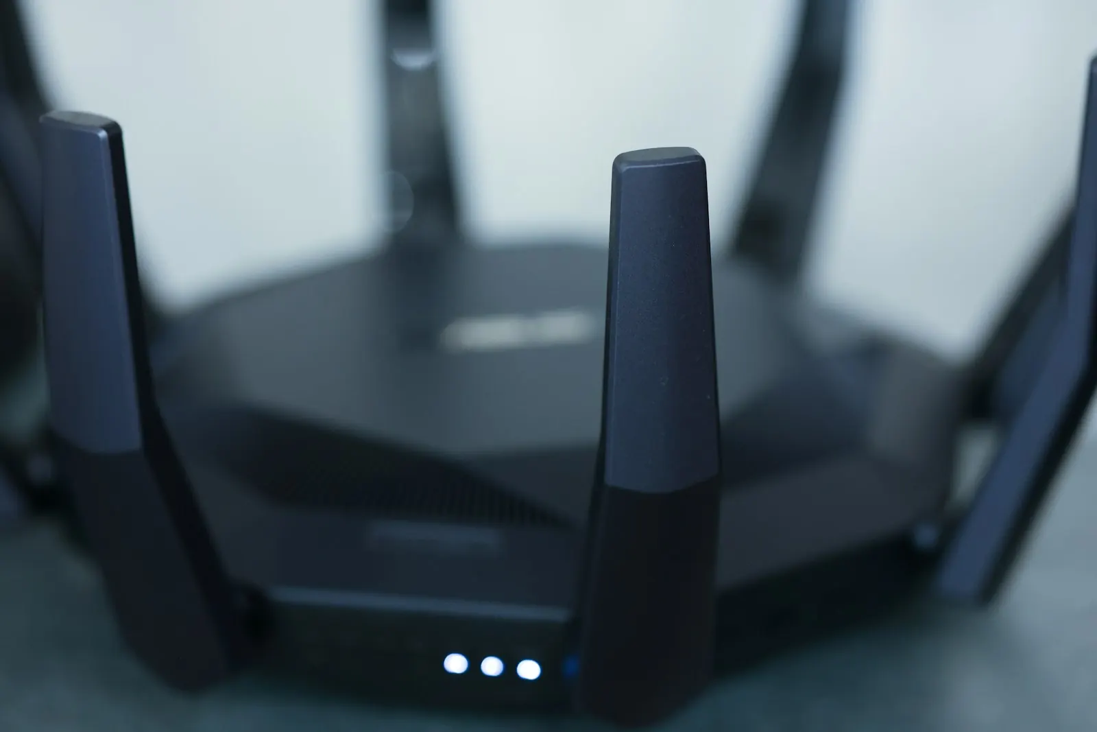 Primer plano de un router inalámbrico, donde se aprecian sus indicadores y antenas internas